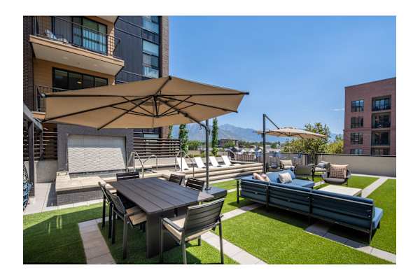 A patio with a table and chairs under an umbrella.